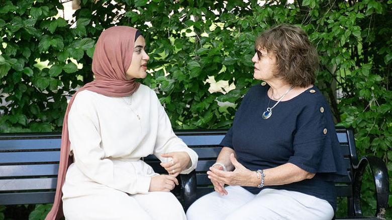 Two women sitting on a bench talking at Penn State Abington near Philadelphia